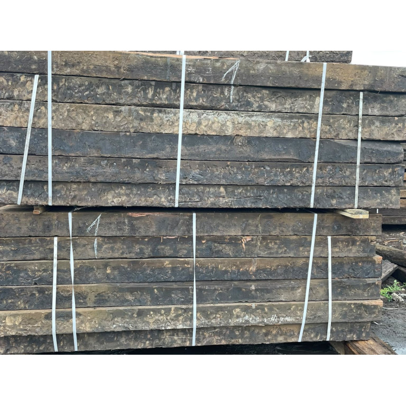 Weathered faces of purified reclaimed railway sleepers in strapped bundles